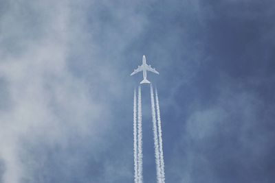 Low angle view of airplane and vapor trail against sky