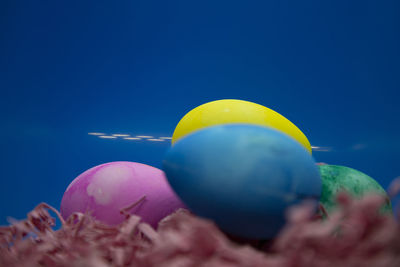 Close-up of multi colored balloons against blue sky