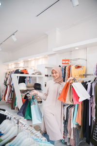 Portrait of young woman standing in shopping mall