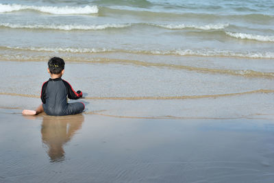 Full length of man sitting on beach