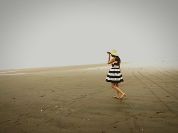 Woman walking on sand at beach