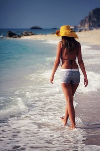 Rear view of woman walking on beach