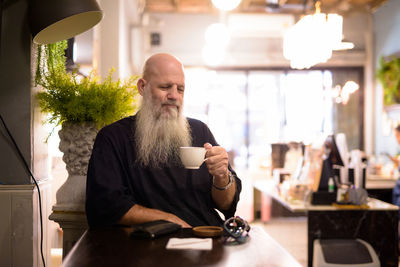 Rear view of man drinking coffee in cafe