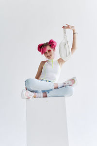 Rear view of woman with arms crossed against white background