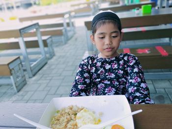 Close-up of girl sitting on table