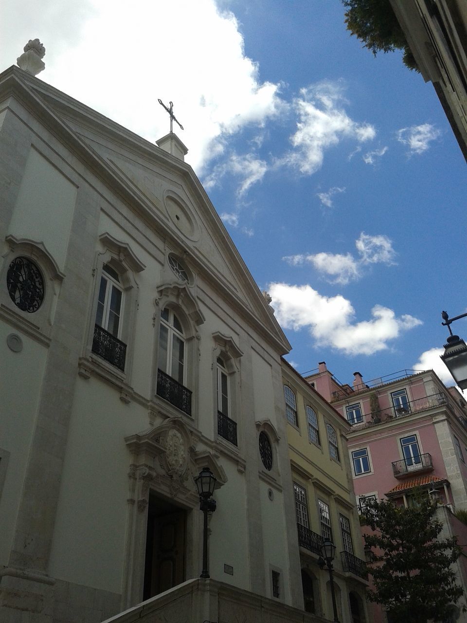 architecture, building exterior, low angle view, built structure, sky, window, building, church, religion, outdoors, place of worship, day, cloud - sky, no people, cloud, city, facade, history, spirituality