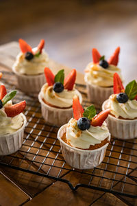 Cupcakes with white icing decorated with berries and mint. delicious dessert. festive bakery.