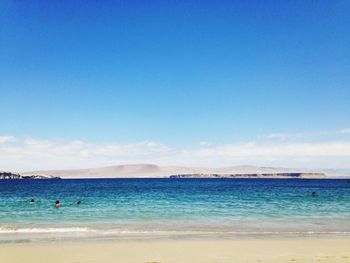 Scenic view of beach against blue sky