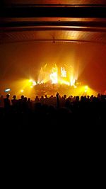 Silhouette people photographing illuminated music concert at night