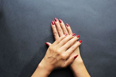 Close-up of woman hand against red background