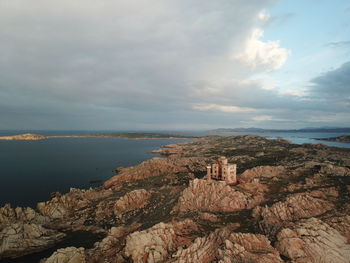 Rock formations by sea against sky