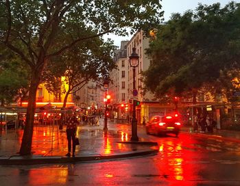 Illuminated city street during rainy season at night