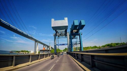 Bridge over road against blue sky