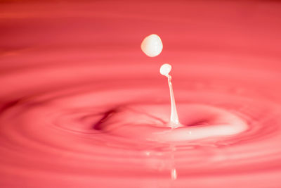 Close-up of wineglass against red background