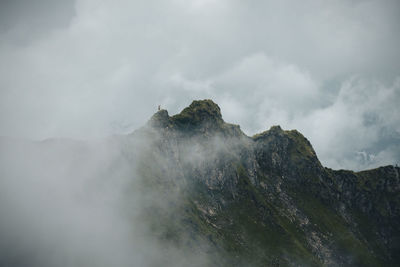 Scenic view of high mountains surrounded by clouds