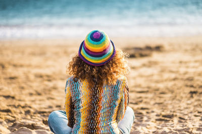 Rear view of woman wearing hat on beach