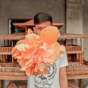 Portrait of young man holding flower