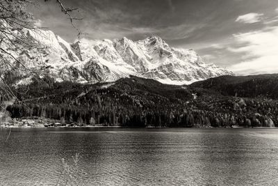 Scenic view of lake by mountains against sky