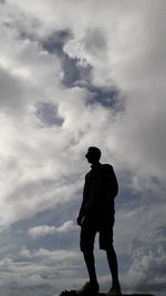 Rear view of silhouette man standing against sky