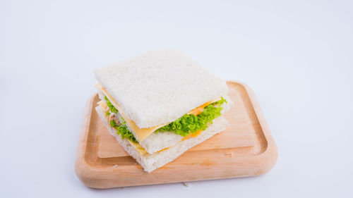 Close-up of bread on cutting board against white background