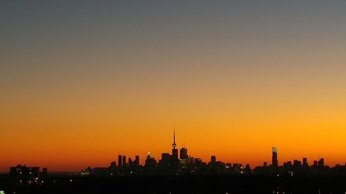 Silhouette cityscape against sky during sunset