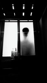 Person behind window in darkroom