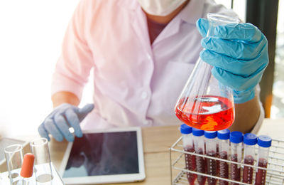 Cropped image of scientist examining chemical in laboratory