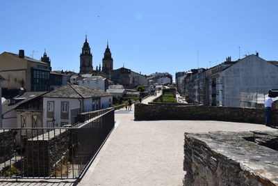 Buildings in city against clear blue sky