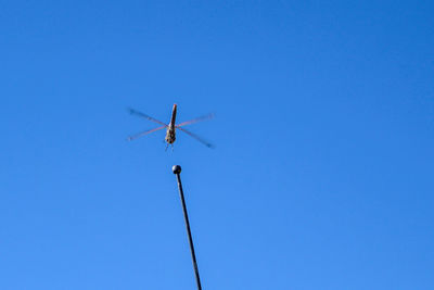 Low angle view of airplane against clear blue sky