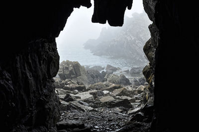 Scenic view of sea seen through cave