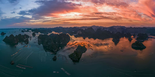 Scenic view of lake against cloudy sky during sunset