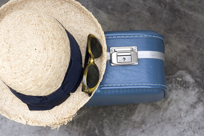 High angle view of hat and sunglasses on briefcase