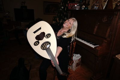 Smiling woman with musical instrument at home