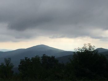 Scenic view of trees and mountains against sky