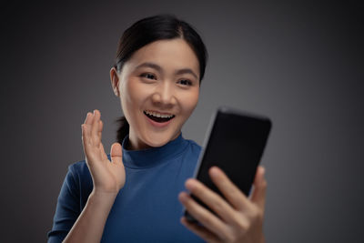 Portrait of smiling young woman using mobile phone