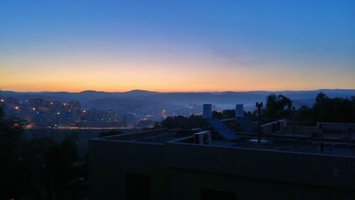 Cityscape against clear sky at sunset