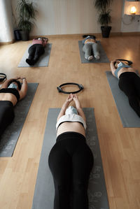 Group of women practicing pilates exercises in class with masks