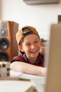 Happy boy watching something on laptop in the living room.