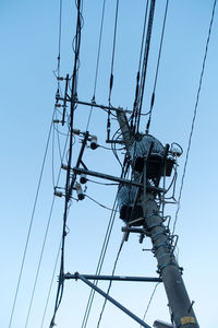 Low angle view of electricity pylon against clear sky