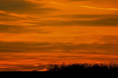 Scenic view of silhouette landscape against orange sky