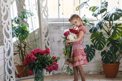 Woman standing by potted plants