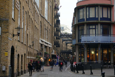 People walking on road along buildings