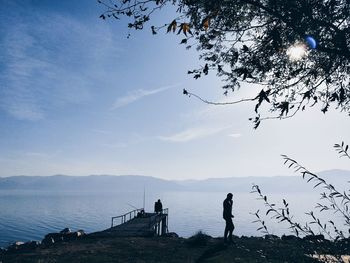 Silhouette people on beach against sky