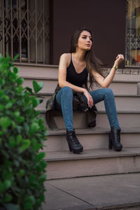 Beautiful young woman sitting on staircase