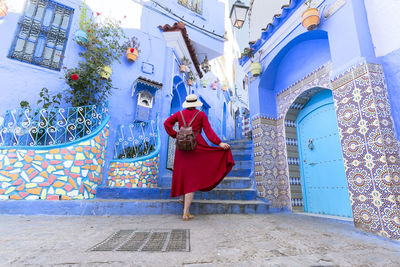 Rear view of woman sitting on street