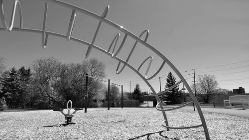 People playing in playground against clear sky