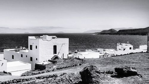 Buildings by sea against sky