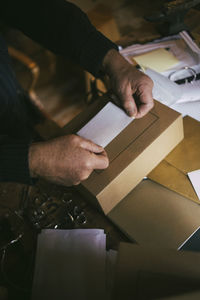 Male entrepreneur's hands labeling on box at workshop