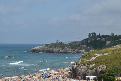 People on beach by sea against sky