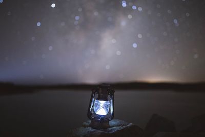 Oil lamp against sky at night